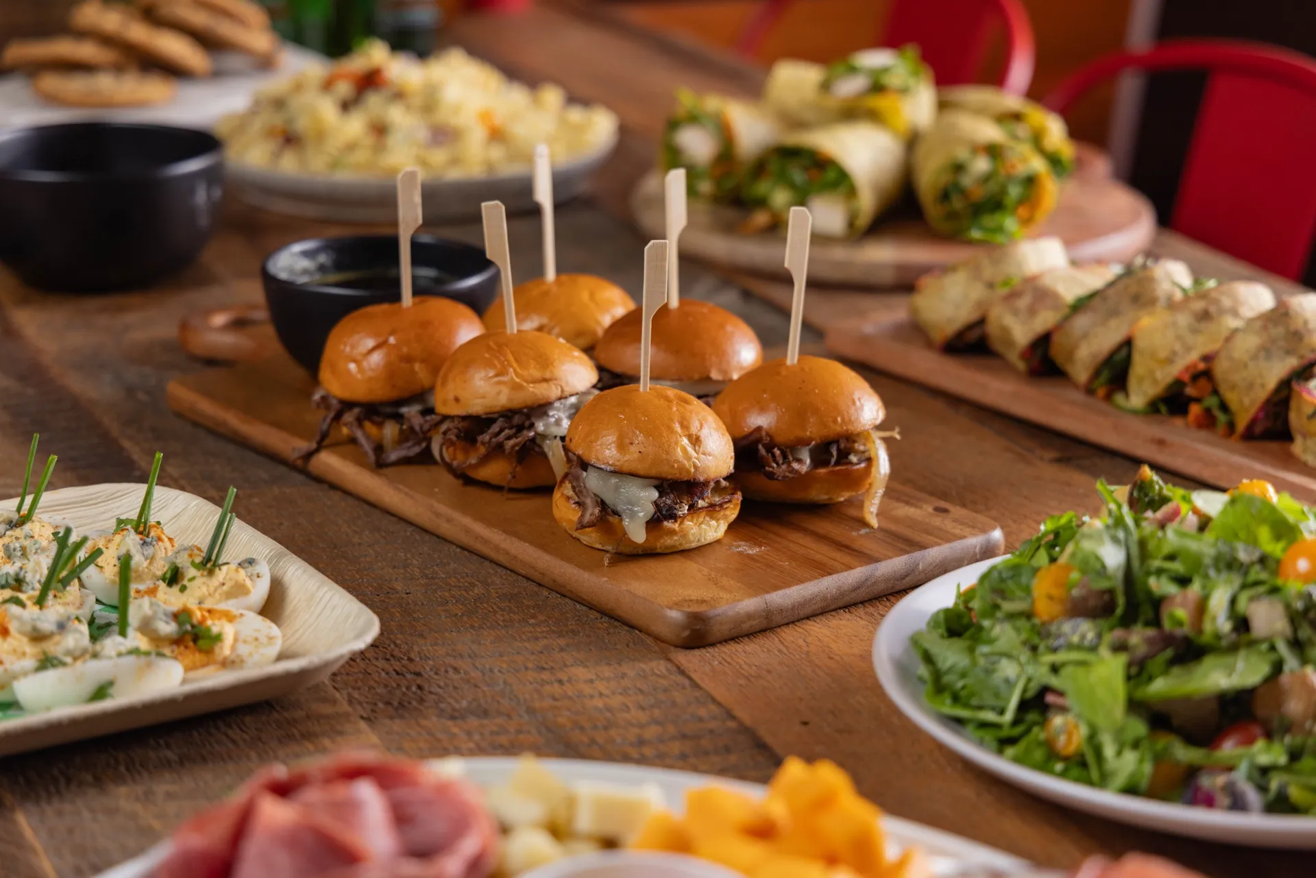 Spread of scratch-made sliders, wraps, and salads at Deli Nerds in Costa Mesa